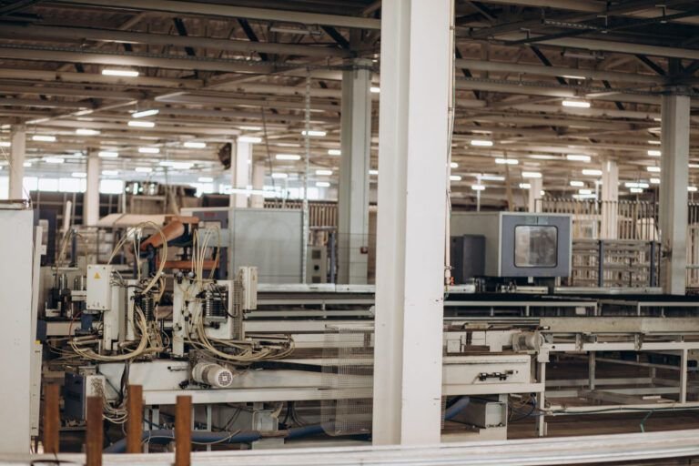 Windows & Doors installation Quebec showing an industrial factory producing aluminum and PVC window and door frames with machines assembling durable, energy-efficient components.