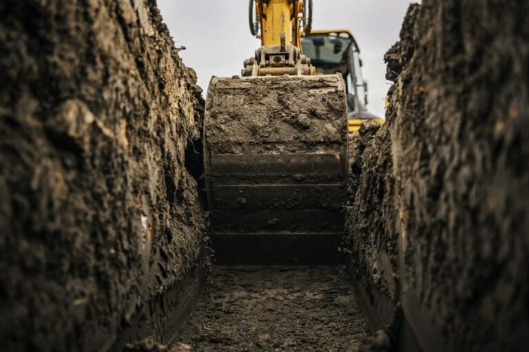 Excavation services in Quebec showing an excavator digging a trench on a construction site, used for earthmoving, foundation work, and site preparation with powerful hydraulic systems for heavy-duty performance.