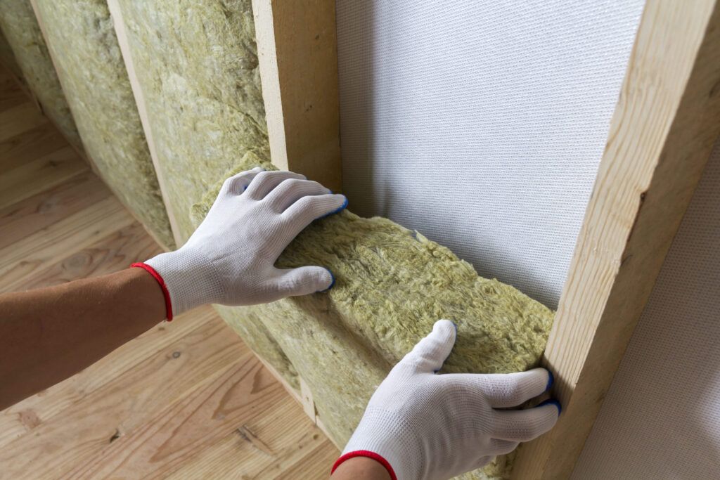 Insulation services Quebec showing the installation of mineral wool insulation, a non-combustible material made from glass or rock fibers used for thermal, acoustic, and fire protection in buildings.